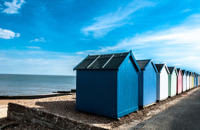 一排明亮的海滩小屋在费利克斯托，萨福克，英格兰，英国