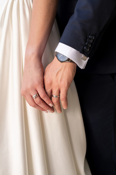 新婚夫妇手牵着手的特写镜头。刚结婚的夫妻结婚戒指近了。婚礼和爱情的概念。