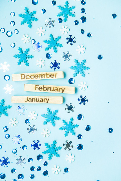 木版上刻着月份的名字——12月、1月、2月，背景是蓝色的雪花和闪光。俯视图