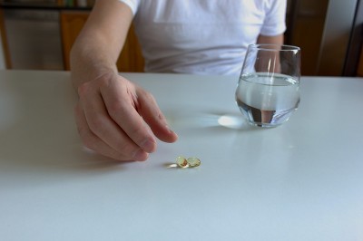 服用欧米加3鱼油补充剂的人。模糊的自然背景。