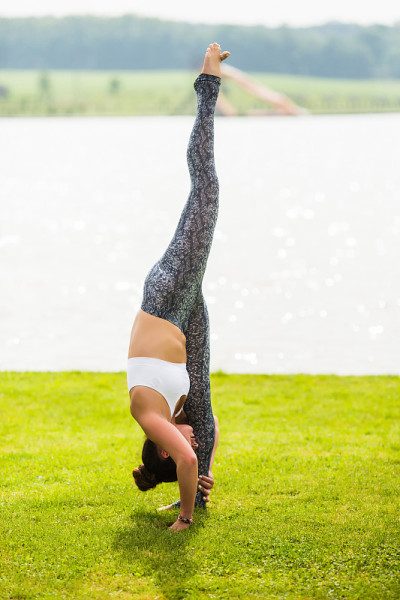 Urdhva prasarita也就是padasana。瑜伽女孩训练户外自然背景。