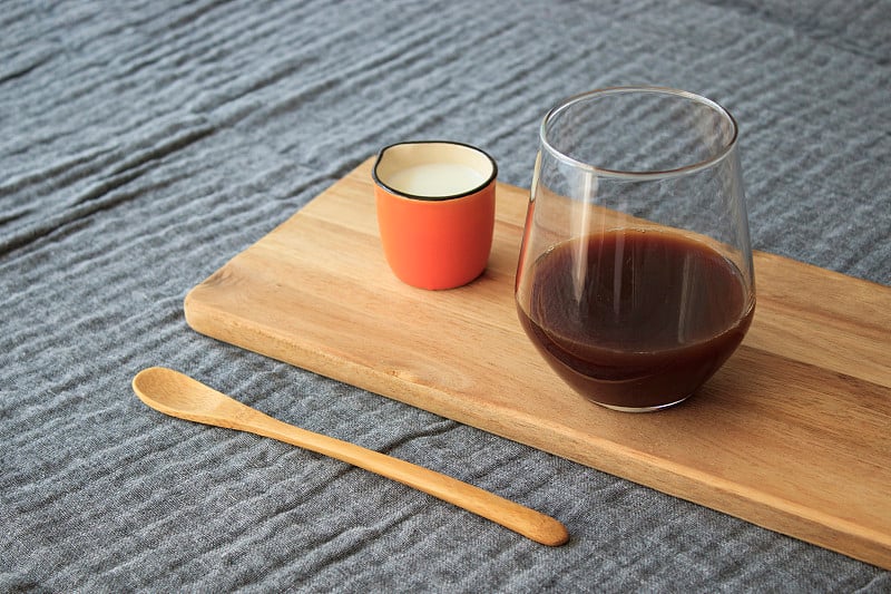 Filter coffee, milk and wooden spoon standing on w