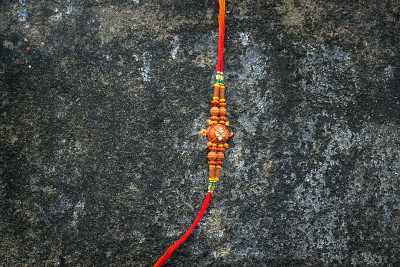 Raksha Bandhan，红色背景上美丽的Rakhi的印度节日。一种传统的印度腕带，象征着兄弟姐