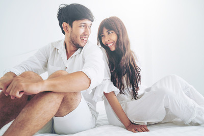 一对幸福的年轻夫妇在家里的卧室里放松。