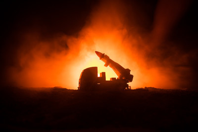 火箭发射与火云。火箭导弹和弹头瞄准夜晚灰暗的天空的战斗场景。《战争背景》中的火箭战车