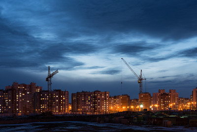 工地上以两座塔吊为背景的多层房屋和一片蓝天、夜景