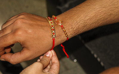 在印度各地庆祝Raksha bandhan节期间，一根神圣的红色Rakhi线被绑在手上。
