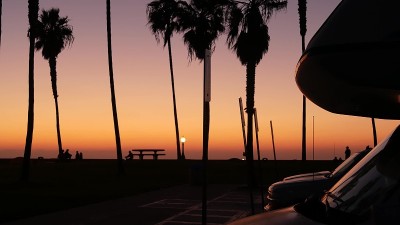 房车，旅行大篷车，棕榈树，日落时的加利福尼亚海滩