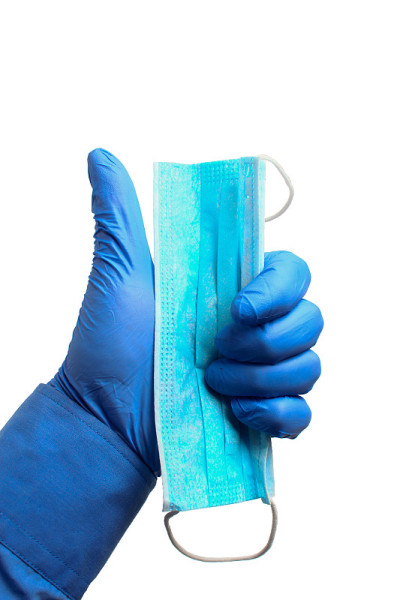 hand in a medical glove shows a thumbs up with a m