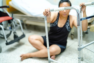 亚洲中年妇女妇女病人跌倒在客厅，因为光滑的表面