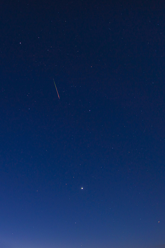 英仙座明亮的红绿色流星在夜空中流动