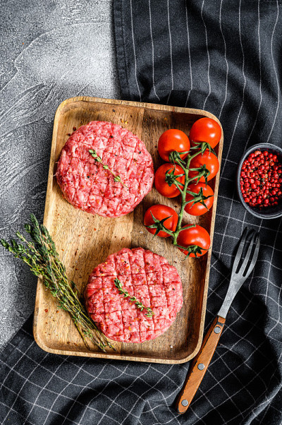 碎牛肉饼，碎肉片。灰色的背景。俯视图