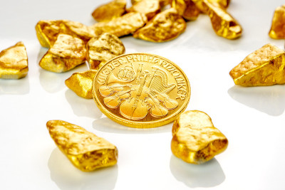 黄金奥地利爱乐一盎司硬币铺在一堆金块上，黄金矿石