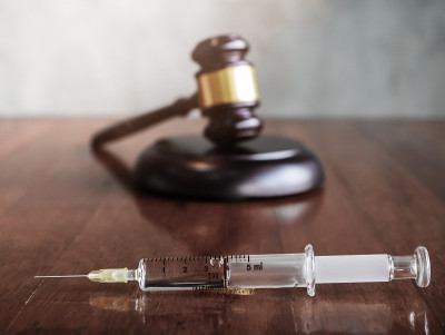 法官在木桌上用木槌和注射器注射