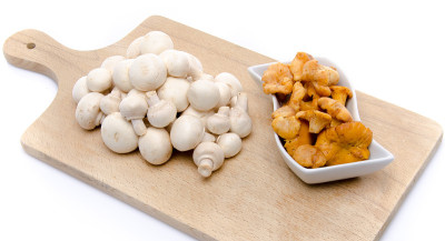 白纽扣和鸡油菌放在木板上