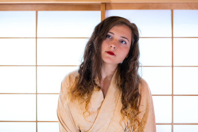 传统的日本房子与滑动门窗户与白种妇女在和服站抬头