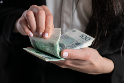 这个女人正数100兹罗提的纸币。