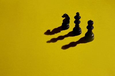 在黄色背景上投下阴影的三把棋