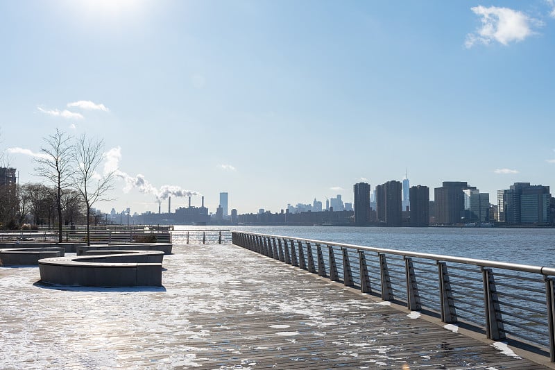 滨水与长凳沿着东河在长岛市皇后区，纽约望向曼哈顿天际线