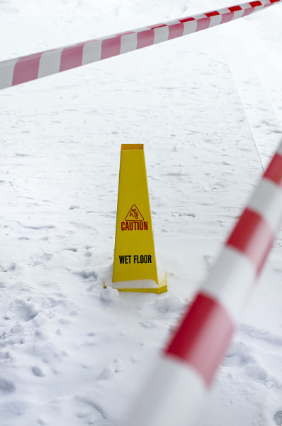 雪地上的黄色塑料湿地板标志。