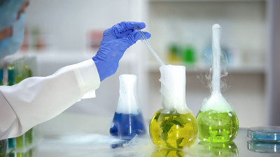 生物化学家从烧瓶中提取黄色有机物样品，植物提取