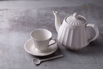 水泥板上的茶壶、奶油、杯子和碟子