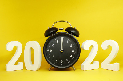 2021年到2022年新年倒计时，数字2022木制字与复古黑色时钟(0时钟)的黄色背景色-节日庆祝概