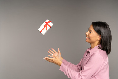 快乐的女人扔掉礼盒。购物，节日期间礼物降价，促销，折扣