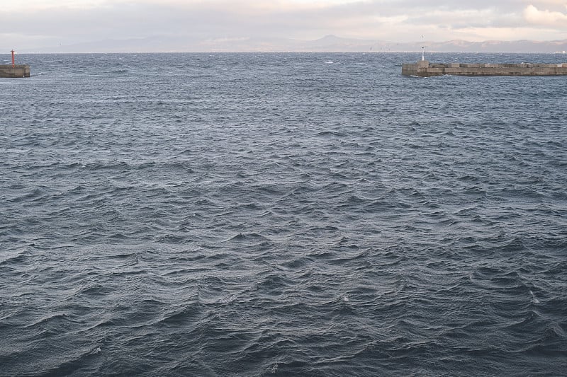 白色的灯塔和汹涌的大海的观点从津鹭海教渡轮-马码头