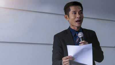 商人是一个演讲者，在会议室、研讨会和会议上向观众和企业家展示和交谈，简要介绍工作和项目。