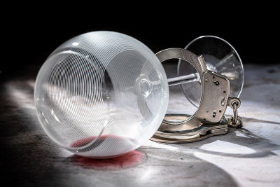 酒后驾车被捕，在黑暗穆迪灯下洒上带有金属手铐的红酒酒杯