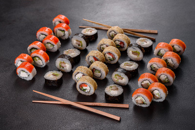 Fresh delicious beautiful sushi rolls on a dark ba