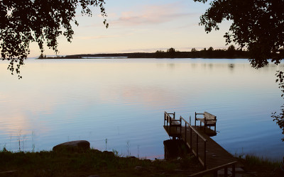 夕阳西下，码头倒映在平静的水面上，码头上湿漉漉的脚印