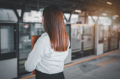 一位亚洲妇女在地铁里排队等火车。保持社交距离预防Covid - 19爆发。火车旅行的概念。u200b