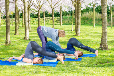 瑜伽老师帮助年轻女性进行Halasana