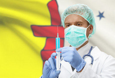手持注射器的医生和加拿大省旗帜背景系列-努勒维特
