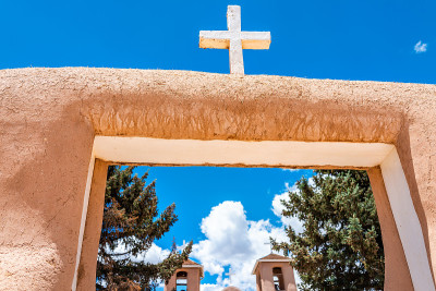 Ranchos de Taos的旧金山阿西斯教堂的特写与十字和门在新墨西哥低角度仰望天空