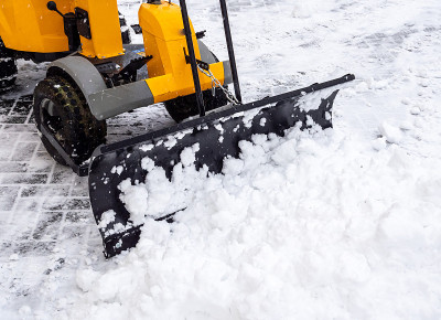 用拖拉机在人行道上推雪