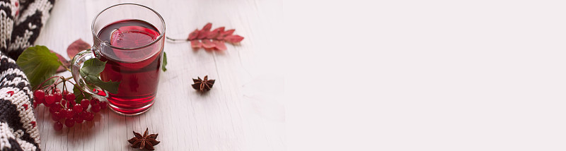 白色横幅与文字空间与秋天静物从杯子与红茶，温暖的围巾和干燥的秋天红叶“n