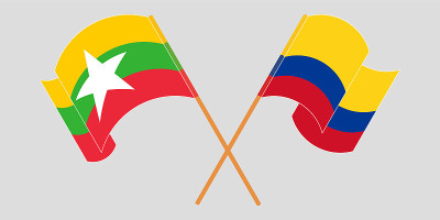 Crossed and waving flags of Myanmar and Colombia