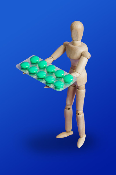 蓝色上有药丸的木制玩具人物
