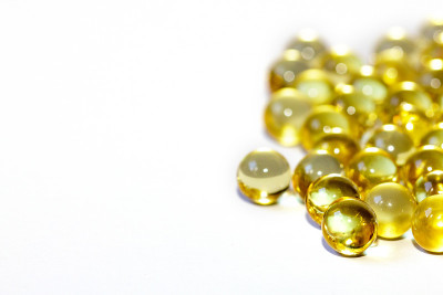 黄色鱼油胶囊，白色背景。Omega3型维生素特写。胶囊鱼油宏。维生素对健康。