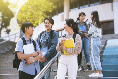 快乐的少年学生在楼梯上交谈和行走