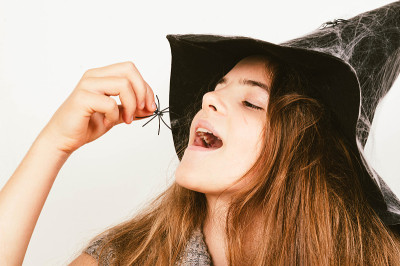女孩在女巫的帽子拿蜘蛛万圣节