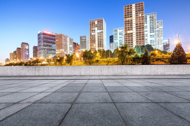 空旷的城市广场路和现代化的商务区办公楼在夜晚的北京