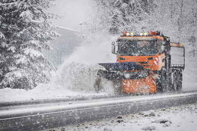 冬季养护公路。雪耕作。扫雪车在下雪。清理路上积雪的卡车