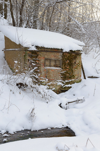 冬日白雪覆盖的森林中摇摇欲坠的小屋