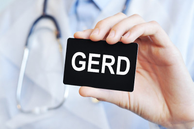医生拿着一张纸卡，上面写着GERD，医学概念