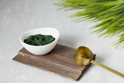 螺旋藻粉在灯光背景下。为纯素、素食或植物性饮食提供健康的营养补充。含有多种维生素