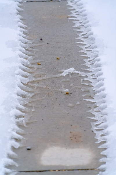 水泥地上的雪地上有轮胎印